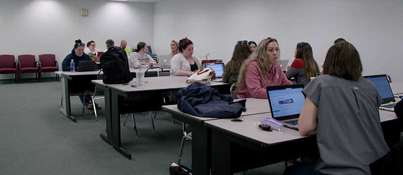 Classroom of students doing schoolwork on their laptops.