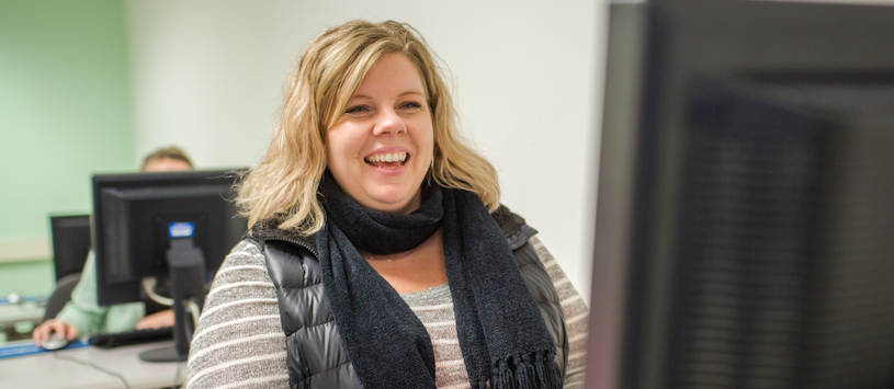 A woman smiling at her computer